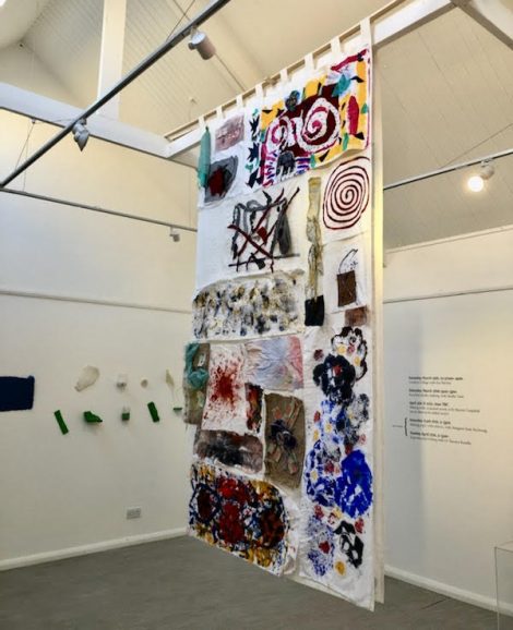 Image of the large emotions mural Sue and her students made, hung in a gallery